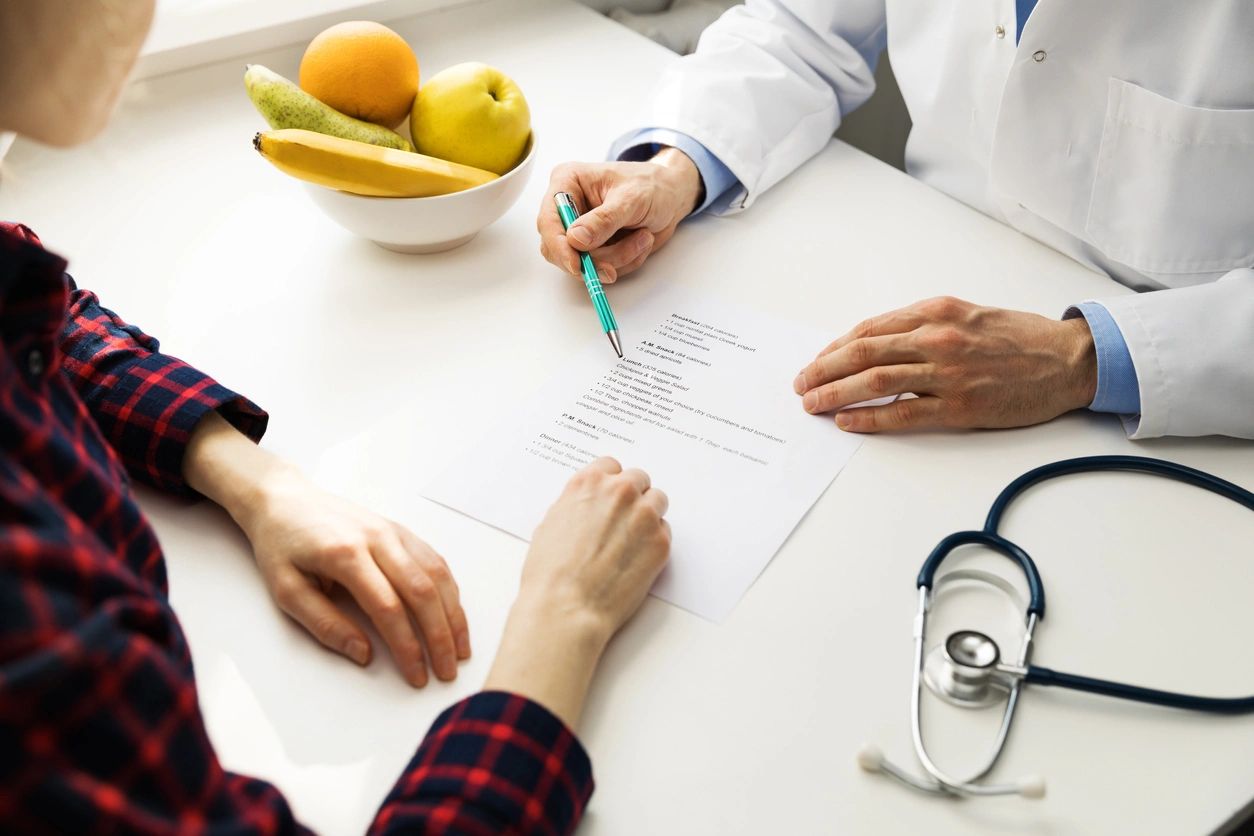 doctor and patient going over medical paperwork at a table