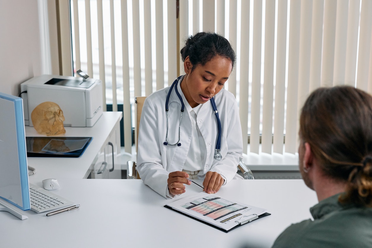 doctor setting up stat collection services with a man in an medical office setting