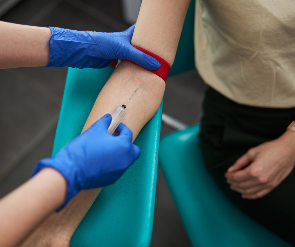phlebotomist sticking a needle in arm for blood drawing
